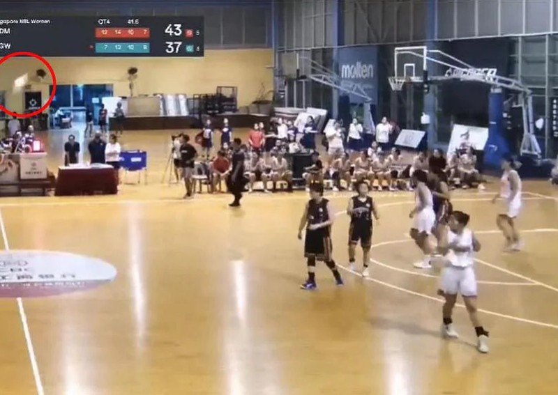 Ceiling light drops during basketball match, narrowly missing some
